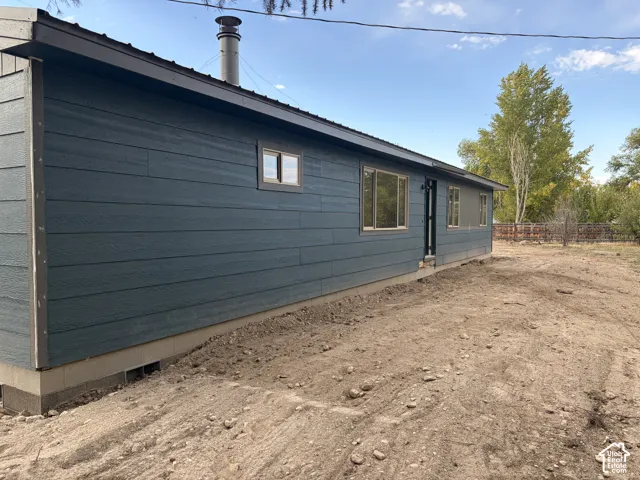 Dark blue siding with a matching dark roof, complemented by a metal chimney