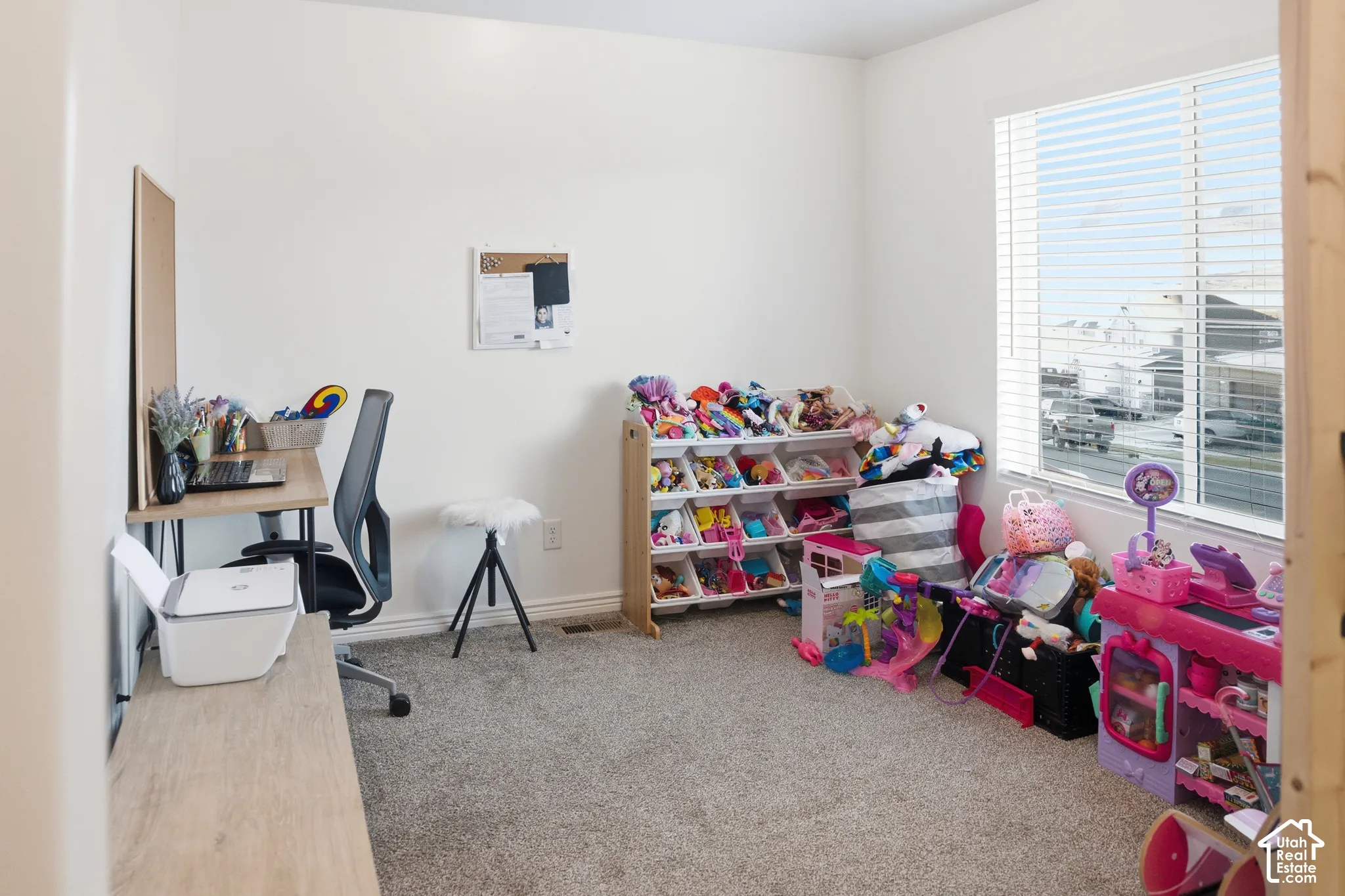 Carpeted flooring, white walls, window with blinds, and built-in shelving