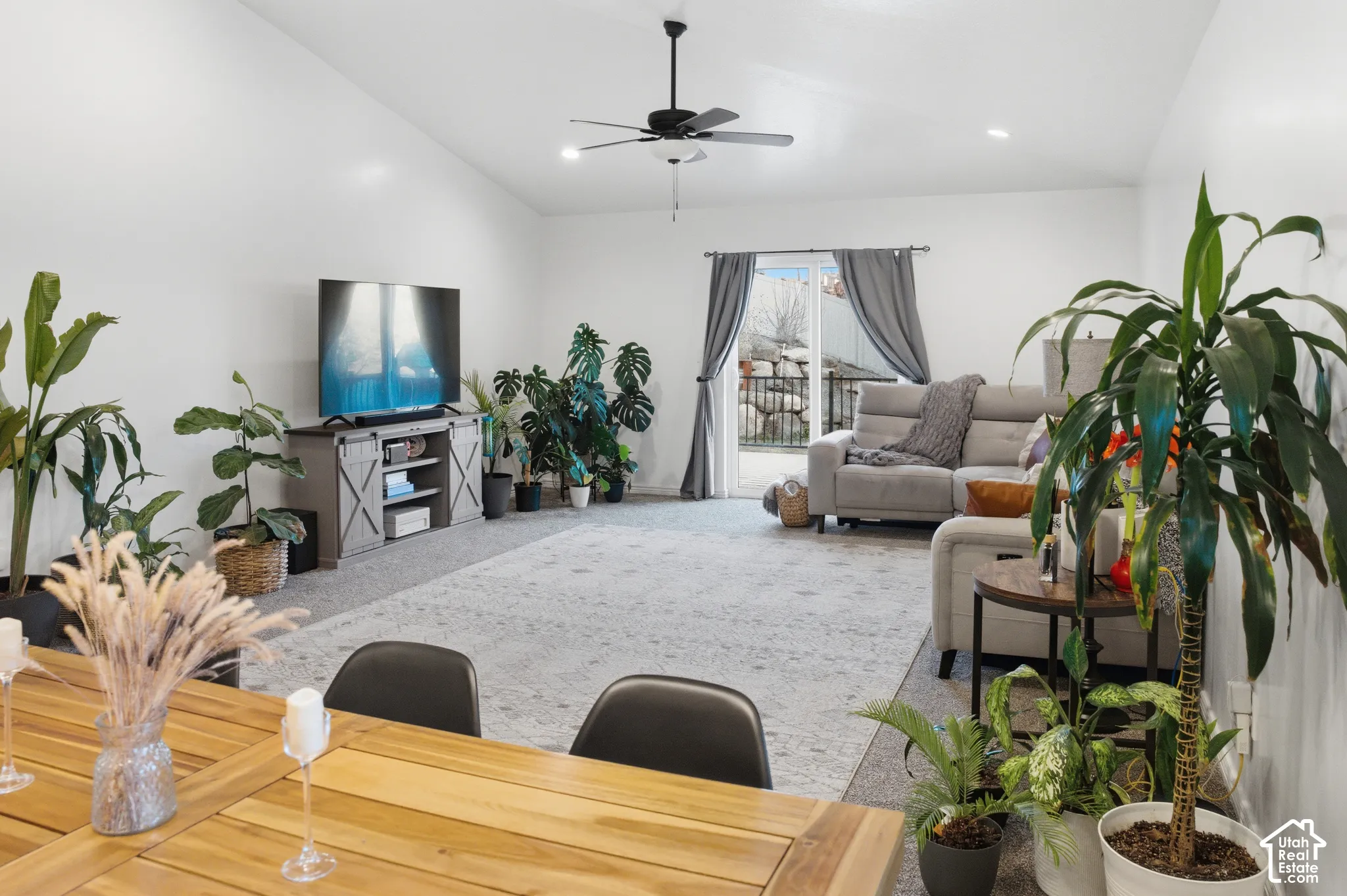 Vaulted ceilings, recessed lighting, ceiling fan, sliding glass door, and wood-finish dining surface