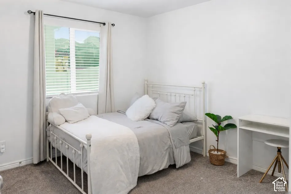 Carpeted flooring, white walls, and a window with blinds