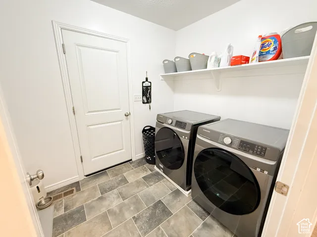 Utility room with durable tile flooring and a built-in wall shelf