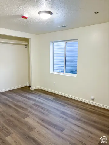 Wood-finish flooring, white walls, and a built-in closet with shelving
