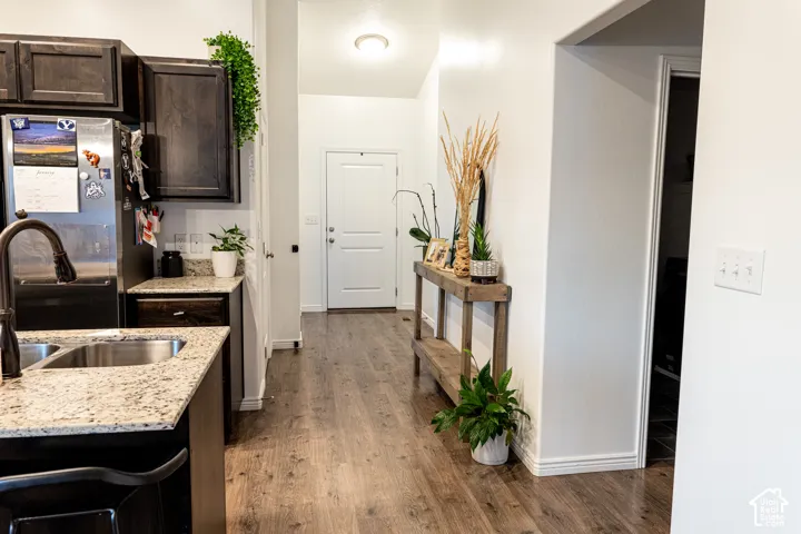 Kitchen with dark wood cabinetry, light-toned countertops, and a stainless steel sink with a gooseneck faucet