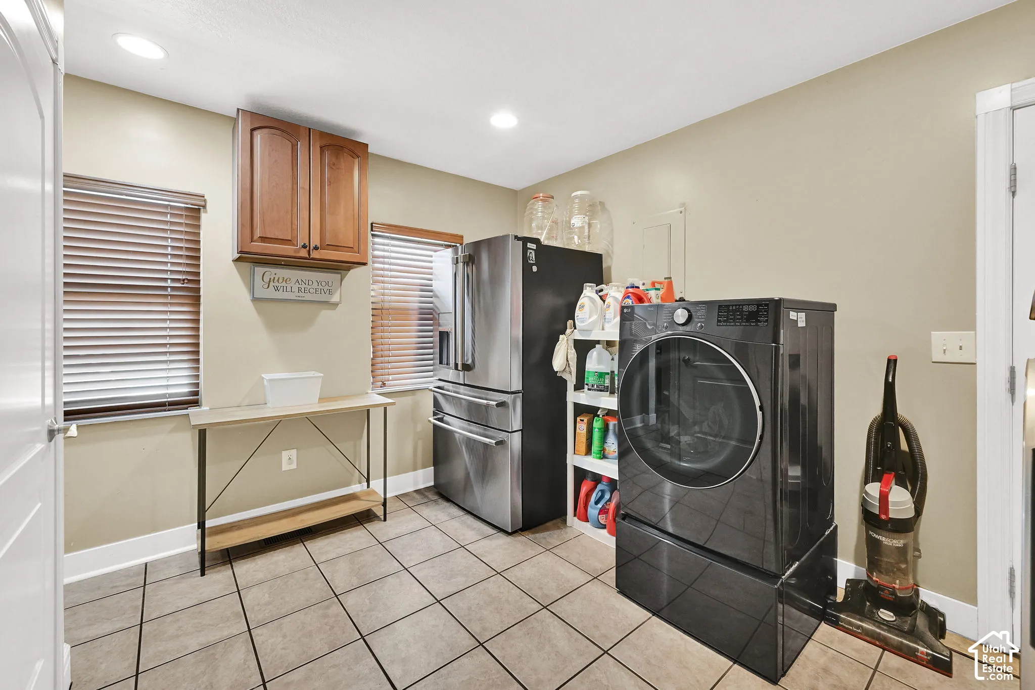 Tile flooring, recessed lighting, wood-finish cabinetry, and two windows with blinds