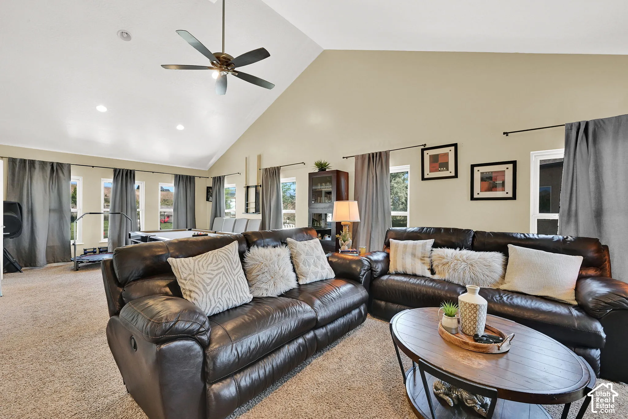 Vaulted ceiling with a ceiling fan, recessed lighting, and multiple windows