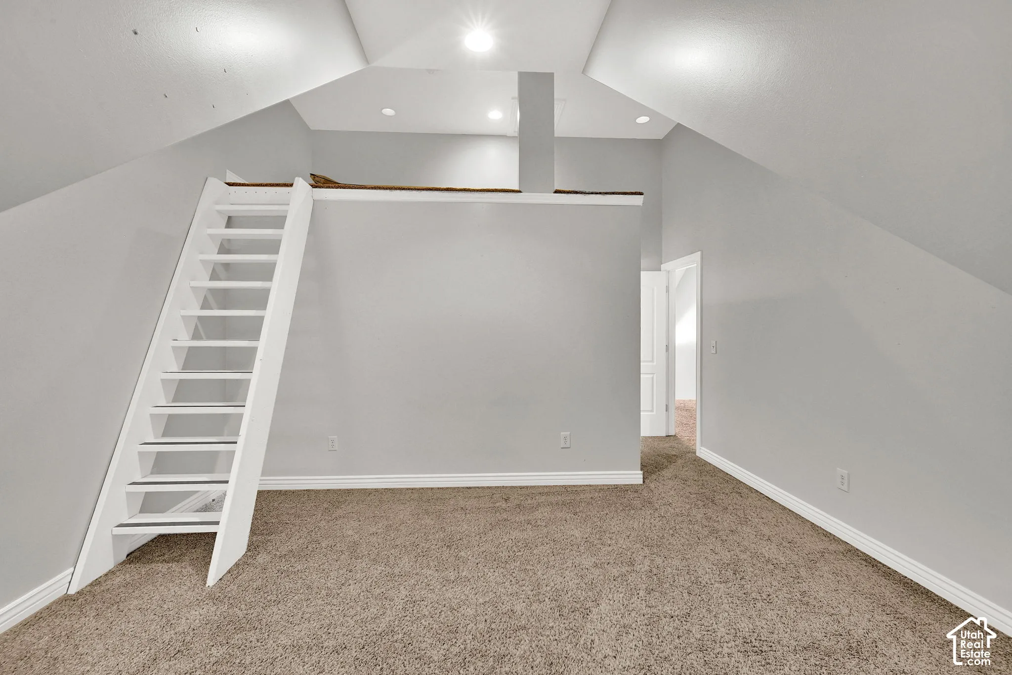 Carpeted room with white trim, a built-in loft, recessed lighting, and a white ladder access