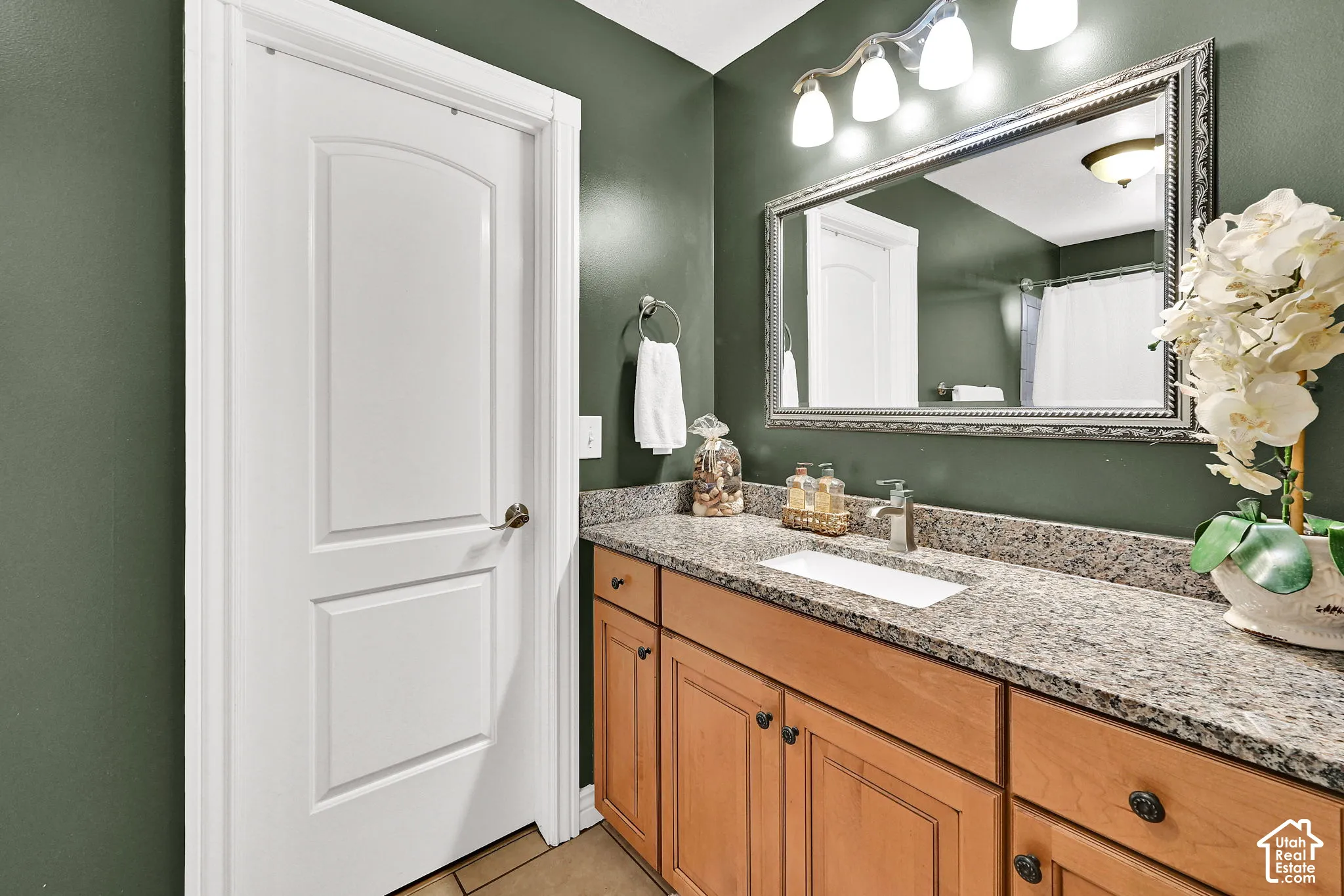Vanity featuring a rectangular undermount sink, a granite-finish countertop, and wood-finish cabinetry