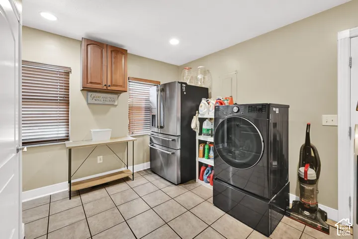 Tile flooring, recessed lighting, wood-finish cabinetry, and two windows with blinds