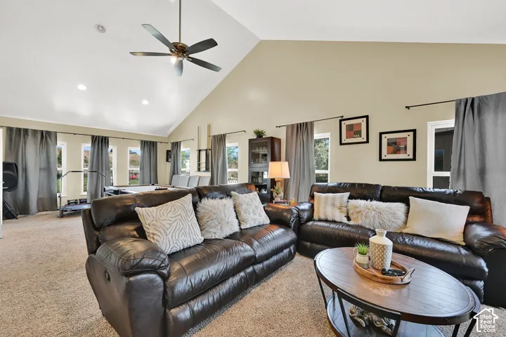 Vaulted ceiling with a ceiling fan, recessed lighting, and multiple windows