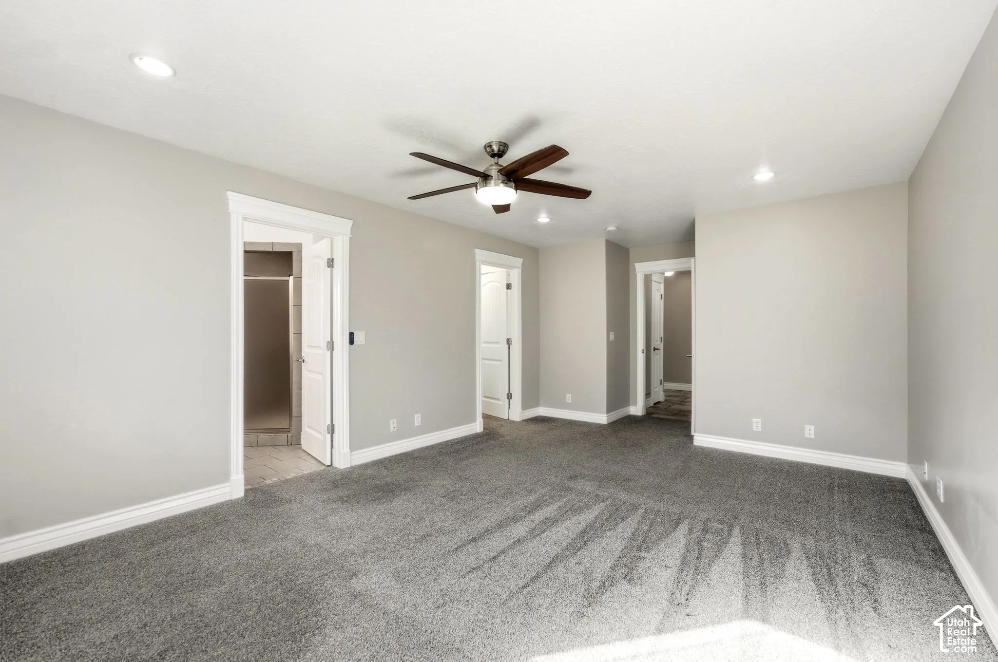 Spacious room with gray carpeting and light gray wall paint