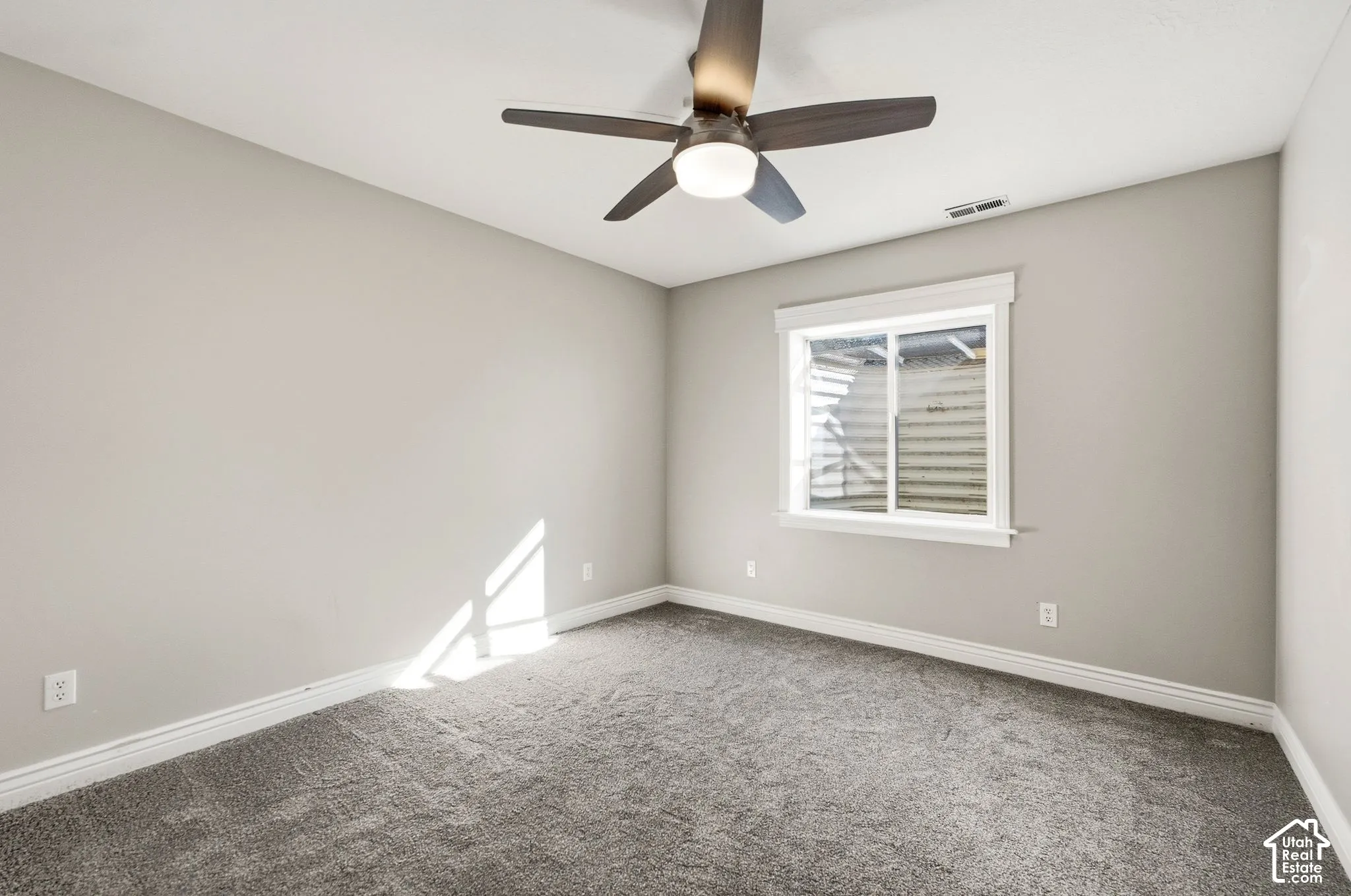 Recessed window with white trim, a ceiling fan with integrated lighting, and carpet flooring