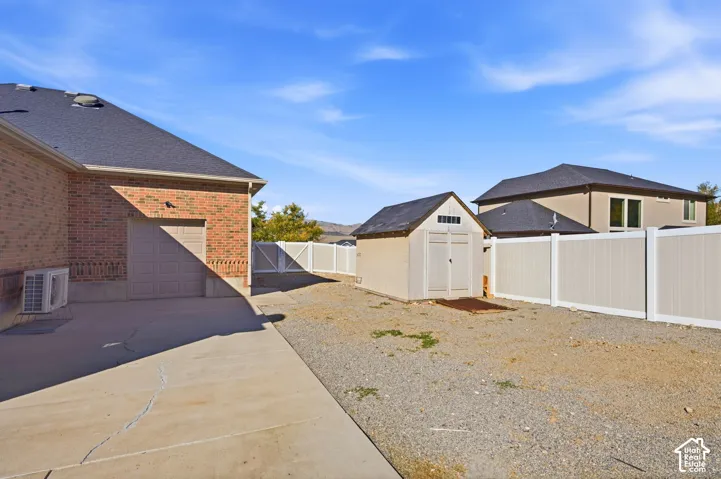 Brick exterior, attached garage, concrete driveway, detached storage shed, privacy fencing