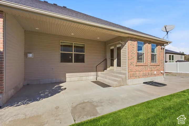 Concrete patio with direct outdoor access, brick and siding exterior, and a covered patio area