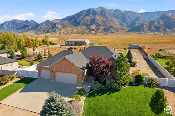 Brick exterior residence featuring a multi-car garage, concrete driveway, and established landscaping