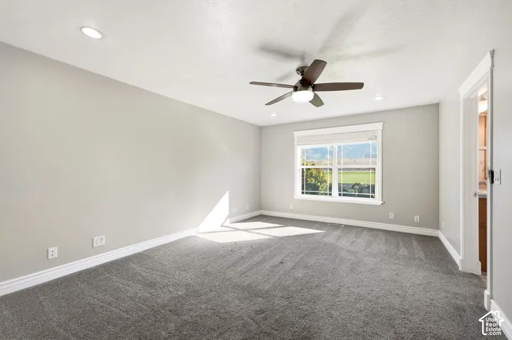 Recessed lighting, ceiling fan with integrated light, carpeted flooring, and a large window with white trim