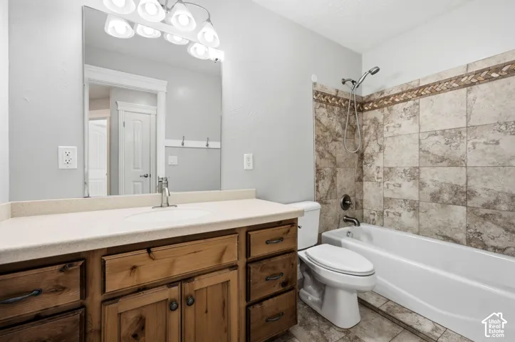 Wood vanity with extensive storage, light-toned countertop, and undermount sink