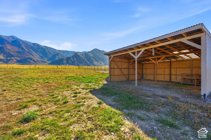 Open-sided structure featuring exposed wood framing, a corrugated roof, and translucent roof panels