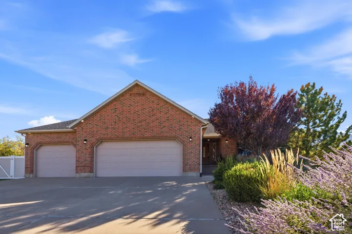 Brick exterior with a gabled roofline, multiple garage bays, and a covered entryway