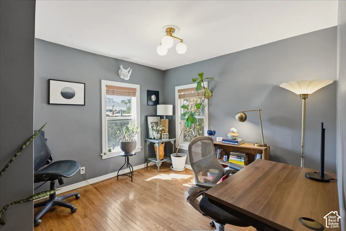 Hardwood flooring, two windows with natural light, recessed ceiling light fixture, and neutral wall tones