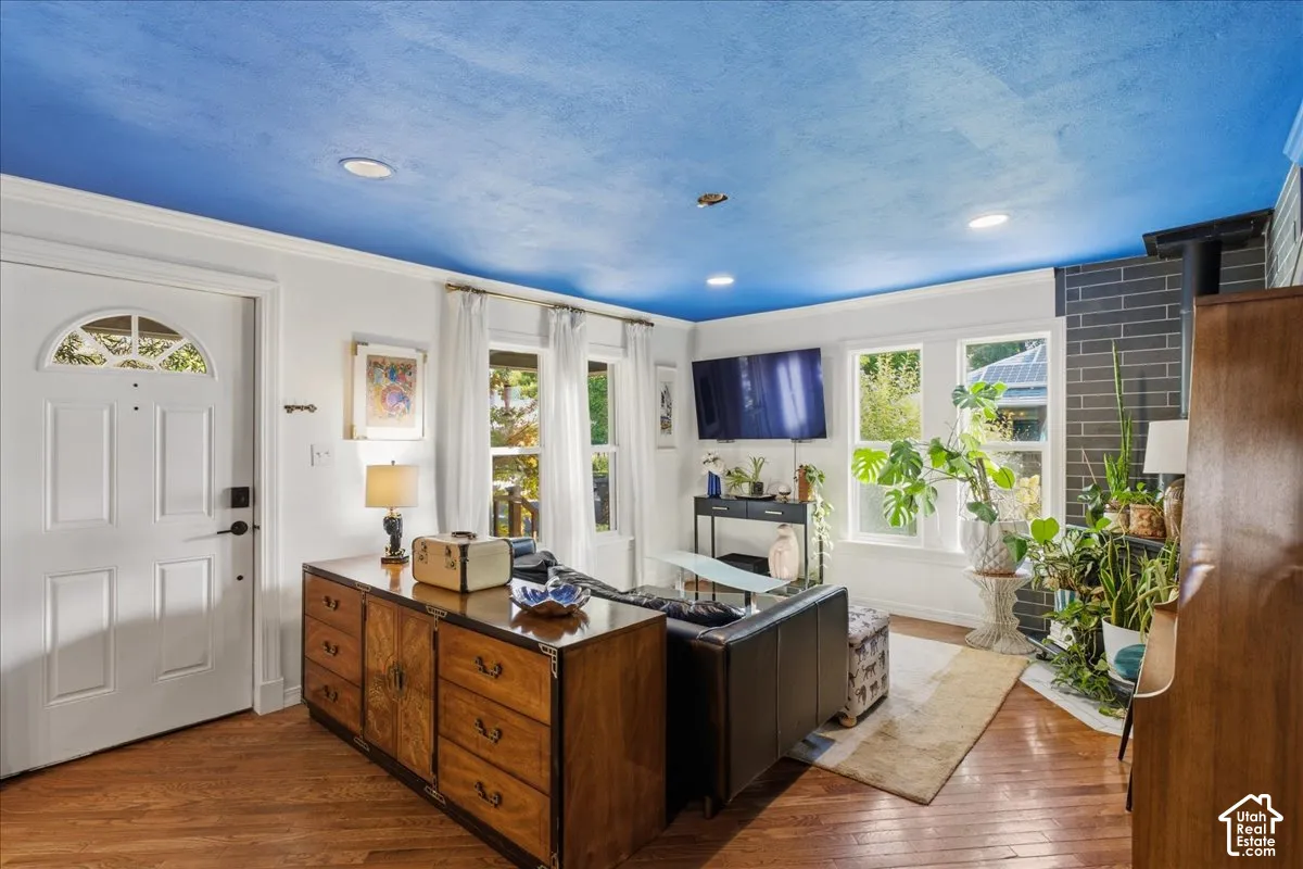Hardwood-finish flooring throughout, multiple windows providing natural light, recessed lighting, and a prominent brick-clad fireplace feature