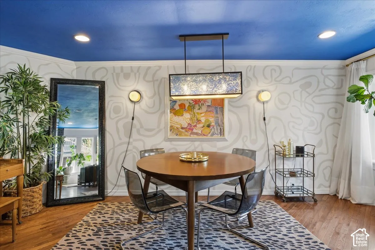 Hardwood flooring, patterned wallpaper, recessed ceiling lighting, contemporary wall sconces, and a linear pendant light