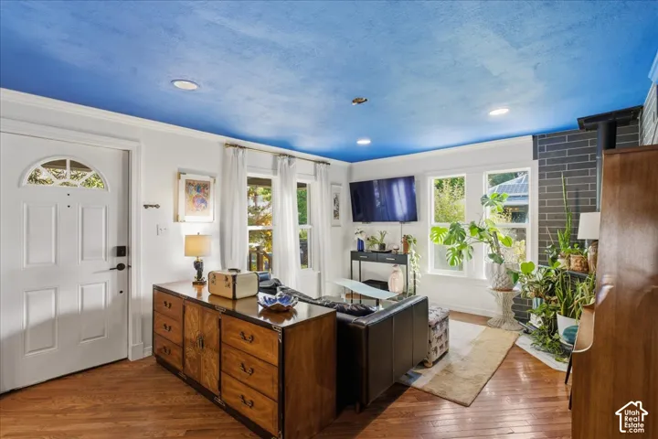 Hardwood-finish flooring throughout, multiple windows providing natural light, recessed lighting, and a prominent brick-clad fireplace feature