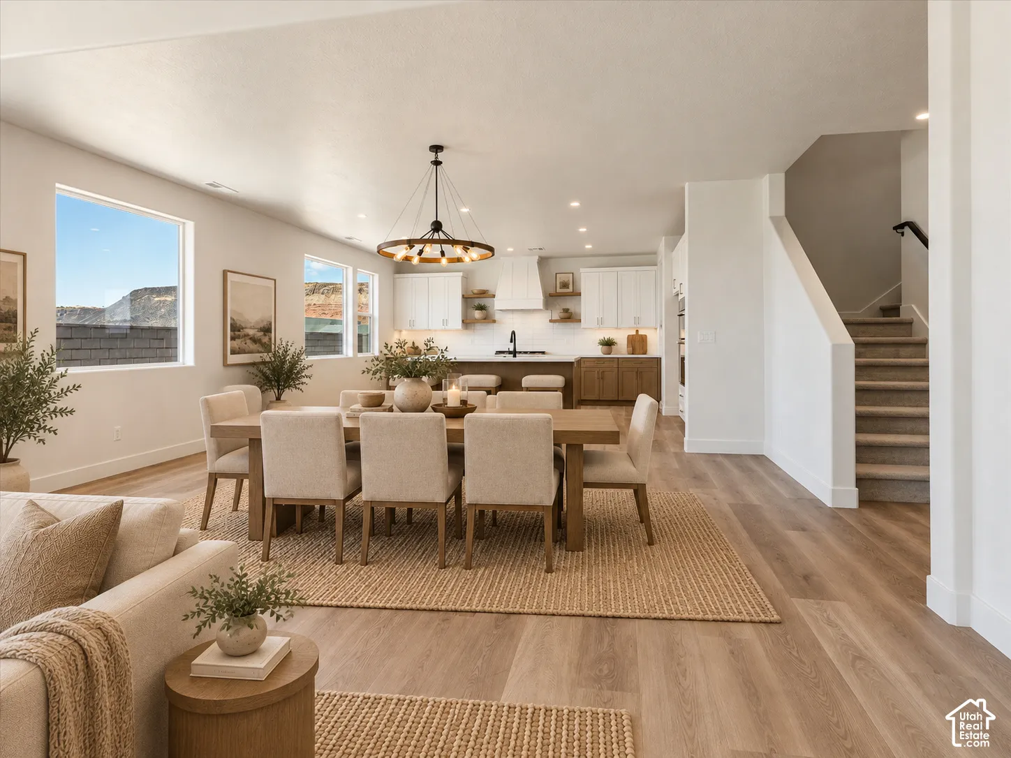 Open-concept living space with wood-finish flooring, a contemporary chandelier, and recessed lighting