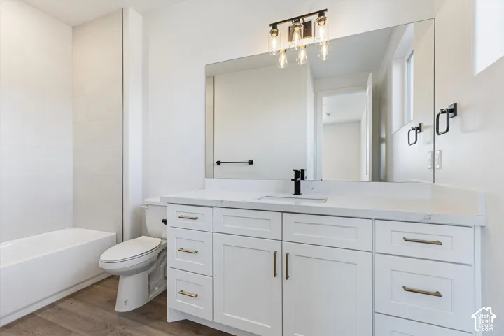 White vanity with integrated sink, stone countertop, matte black faucet, and bronze hardware