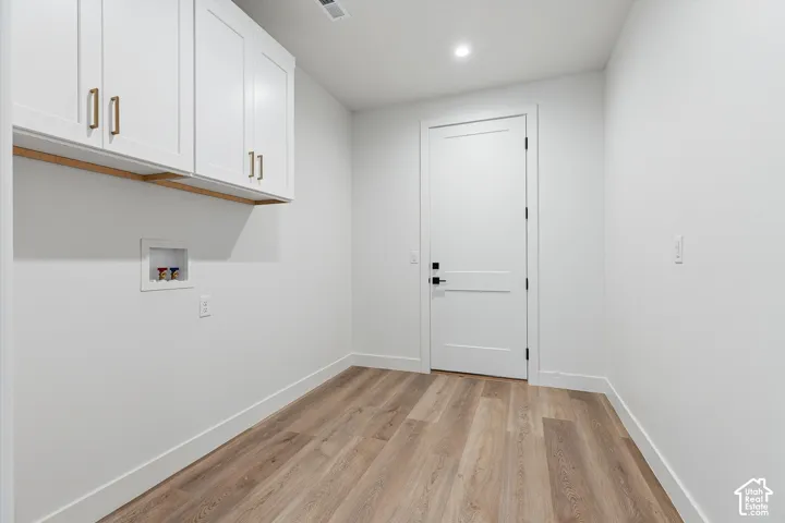 Mud Room with white cabinetry has hookups available