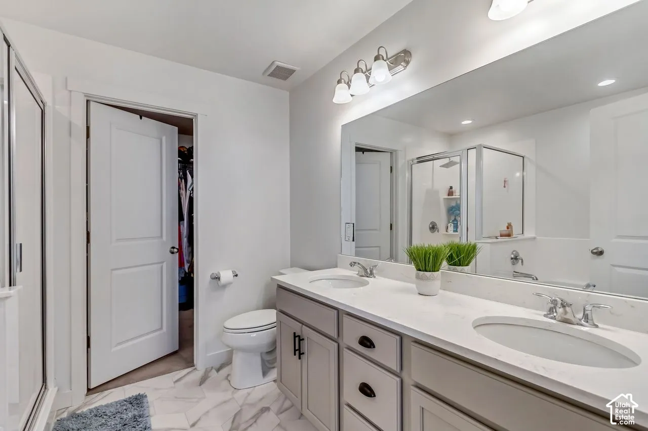 Dual vanity with undermount sinks, stone countertops, and chrome fixtures