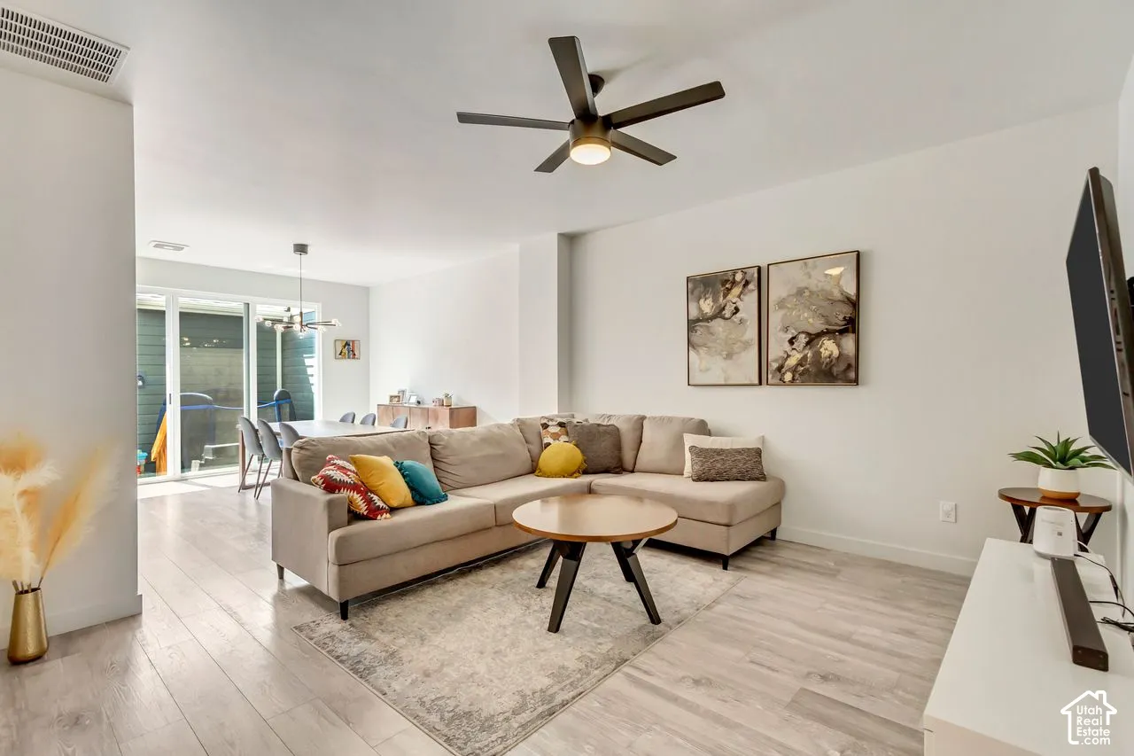 Open-concept living space featuring wood-finish flooring, recessed lighting, and a ceiling fan
