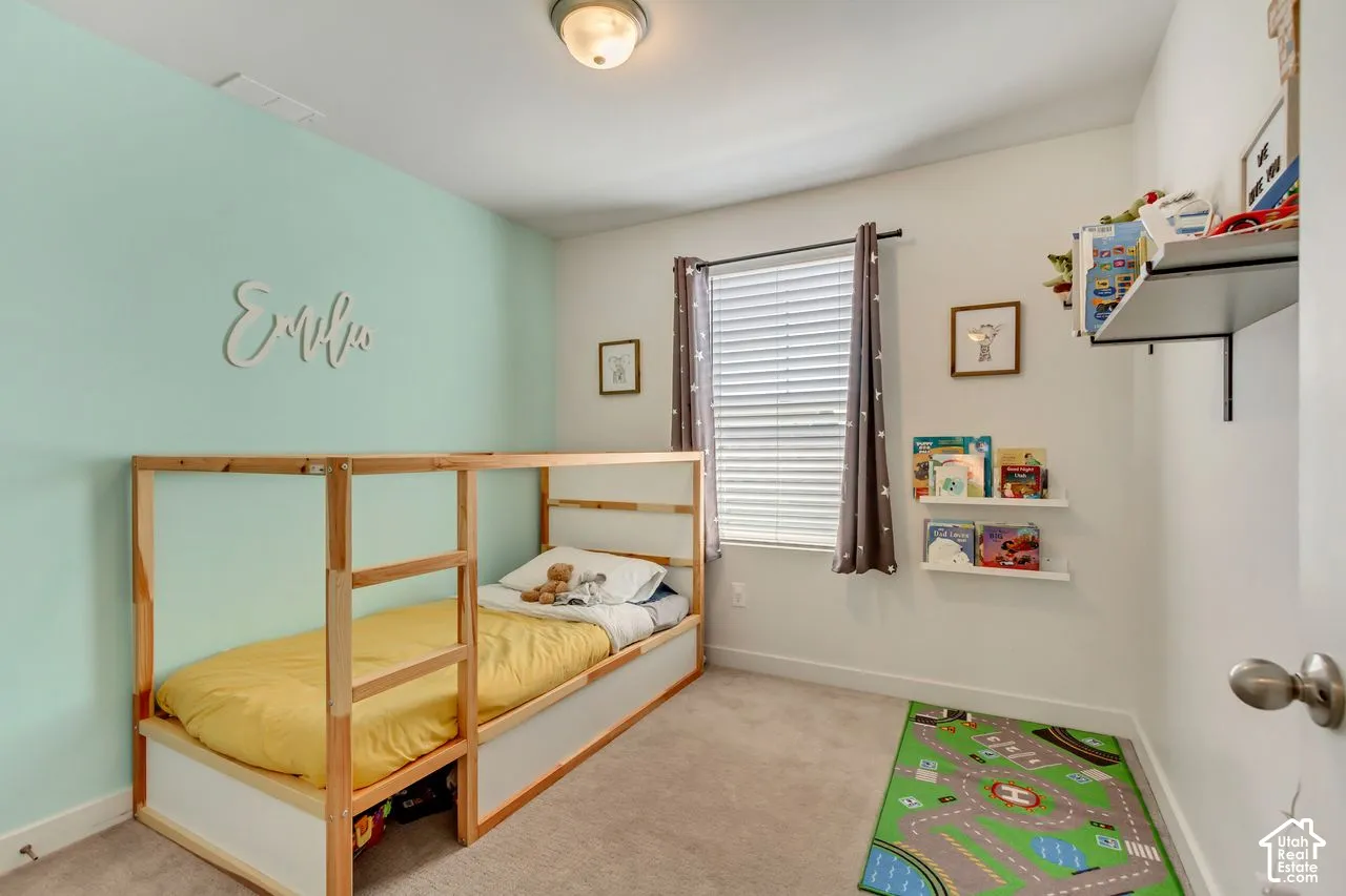 Wall-to-wall carpeting, window with blinds, recessed ceiling light, and built-in shelving