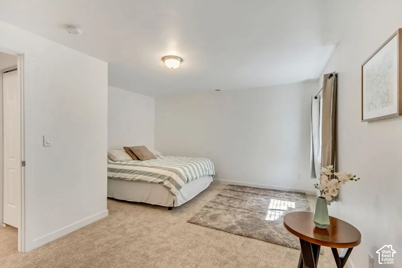 Recessed lighting, light neutral-toned carpeting, and a closet with a solid white door