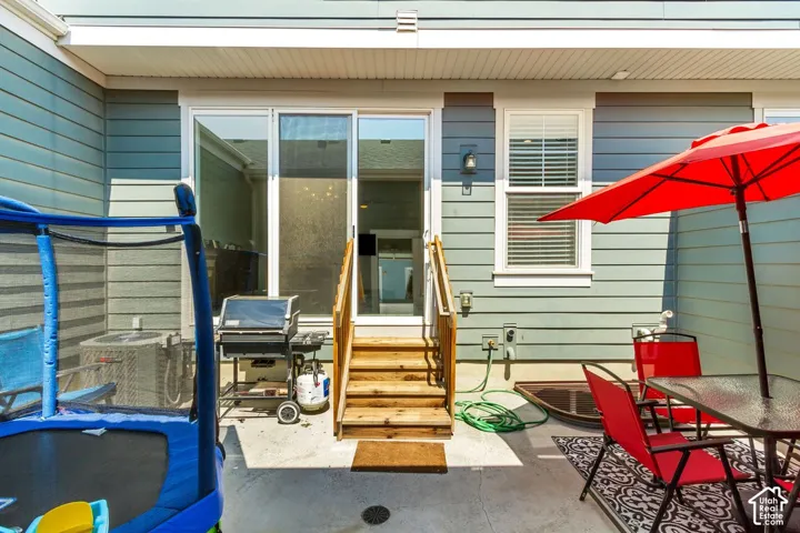 Private patio with concrete surfacing, wood stairs, a sliding glass door, and exterior siding