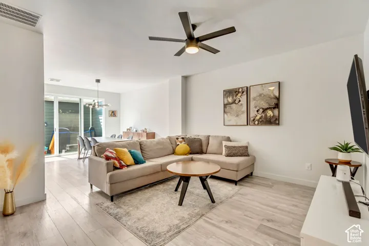 Open-concept living space featuring wood-finish flooring, recessed lighting, and a ceiling fan
