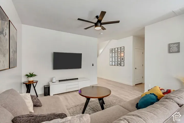 Recessed lighting, wood-finish flooring, white walls, and a ceiling fan with integrated lighting