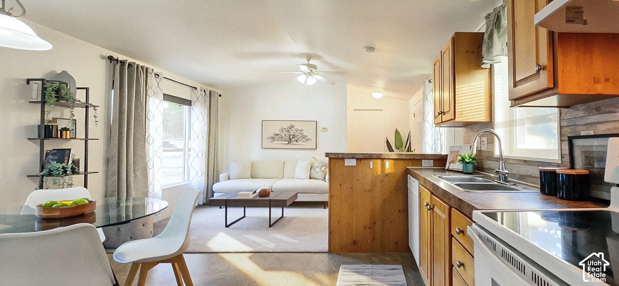 Open-concept living space with a dining area, a living area, and a kitchen featuring wood-finish cabinetry, a double basin sink, and a built-in dishwasher