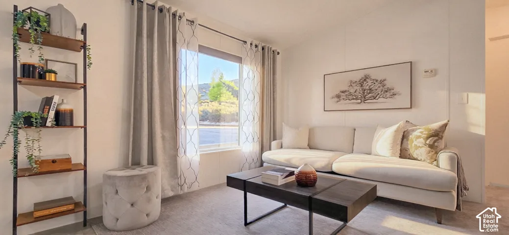 Natural light, light-toned walls, wood-finish shelving unit, window with exterior scenery, soft gray carpeting