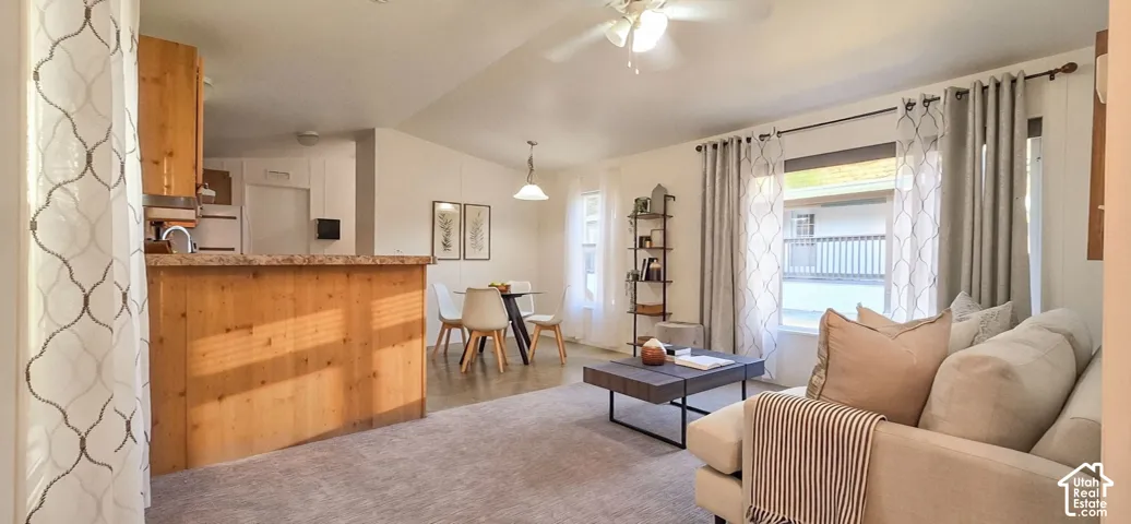 Open-concept living area with a vaulted ceiling and an exposed wood-finish breakfast bar