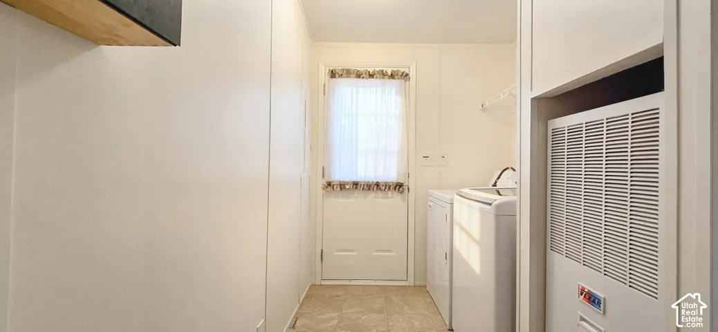 Dedicated utility area featuring a windowed exterior door, built-in wire shelving, and neutral floor tiling