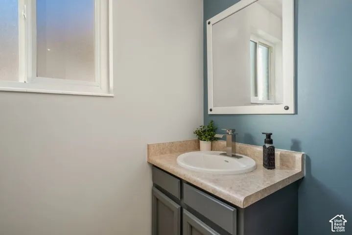Vanity with an oval undermount sink, brushed nickel faucet, and a light-toned countertop