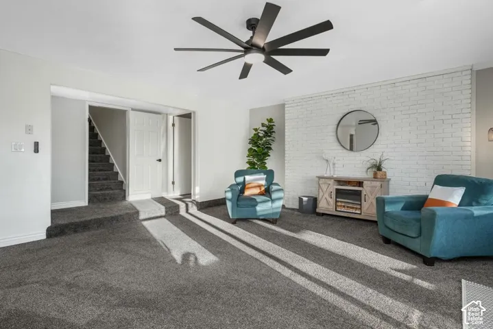 Recessed lighting, ceiling-mounted fan, carpet flooring, and a painted brick accent wall