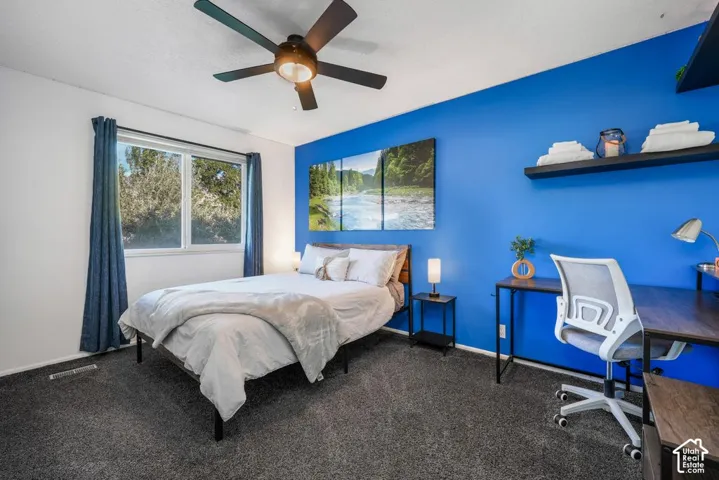 Wall-to-wall carpeting, a multi-pane window, and a ceiling fan with integrated lighting