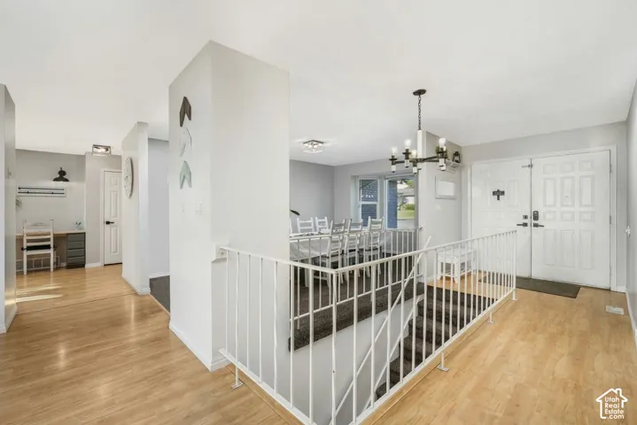Hardwood-finish flooring throughout, a modern chandelier, and a dual front entry door with transom