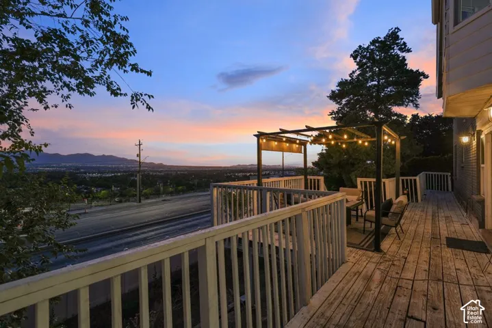 Expansive wood deck with white railings and built-in outdoor lighting