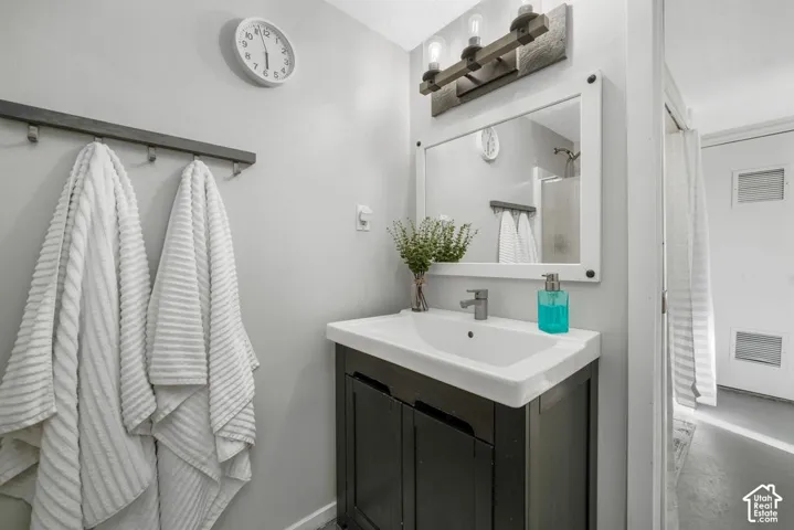 Vanity with integrated sink, wood-finish cabinet, and chrome faucet