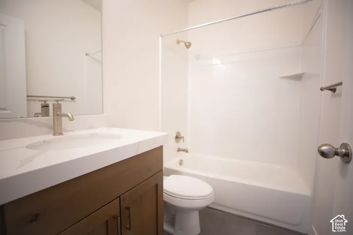 Full secondary bath with stained wood cabinets and quartz slab countertops.