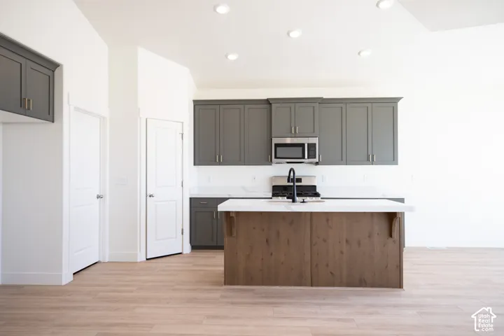 Terrific kitchen with 42" uppers, painted wood cabinets, stained wood island, quartz slab countertops, gas range, dishwasher, microwave and disposal.