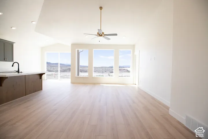 Spacious great room with picture windows, vaulted ceiling and ceiling fan.