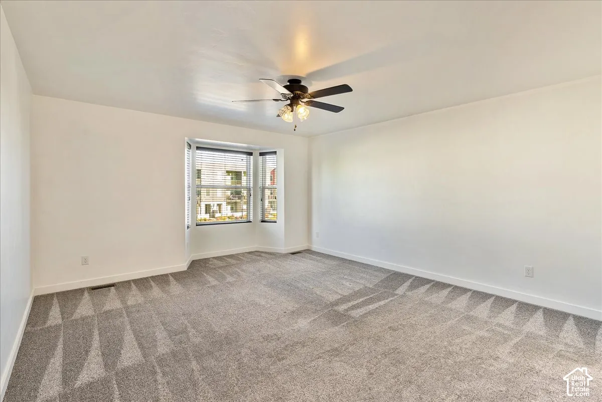Recessed bay window with horizontal blinds, overhead ceiling fan with light kit, and neutral wall paint
